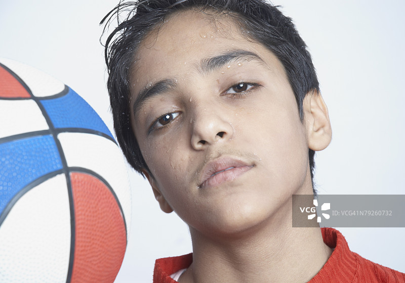 拿着篮球表情严肃的男孩肖像图片素材