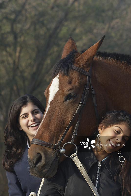 年轻女性和一个少女与马站在一起图片素材