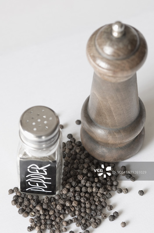 胡椒研磨器和胡椒粉罐与胡椒粒特写图片素材