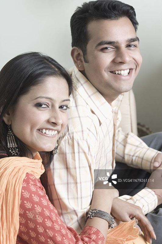 坐着微笑的年轻情侣肖像图片素材