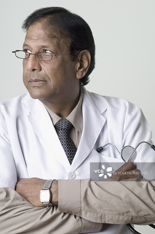 交叉双臂侧视的男医生特写图片素材