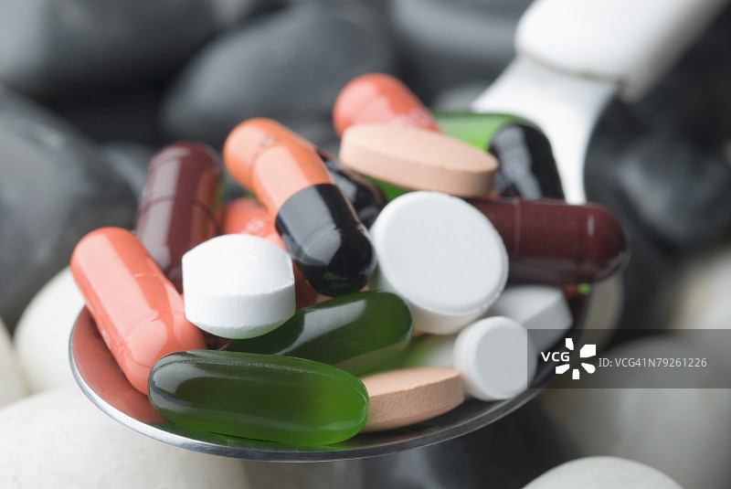 特写：勺子里的胶囊和药片图片素材