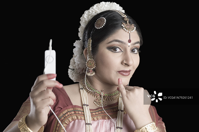 年轻女子跳印度古典舞并听MP3特写图片素材