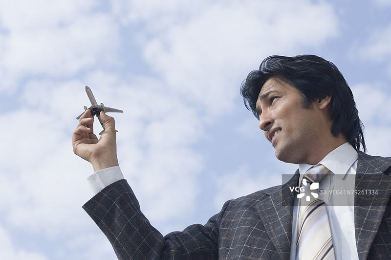 商人手握模型飞机的特写镜头图片素材