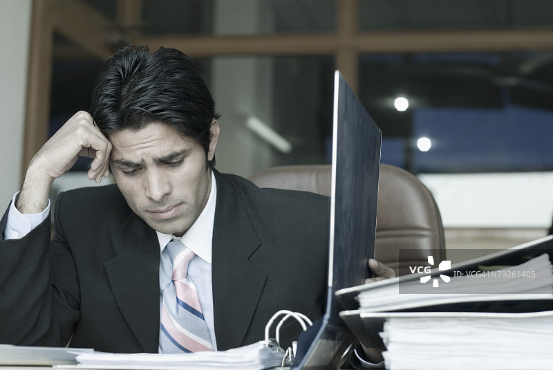 在办公室里看文件的商人图片素材