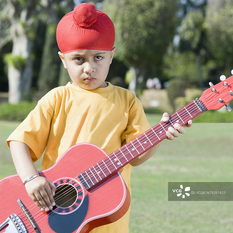 公园里一个男孩在弹吉他的特写镜头图片素材