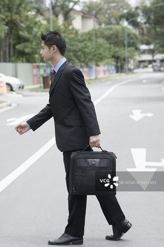 商务男士过马路的侧面照图片素材