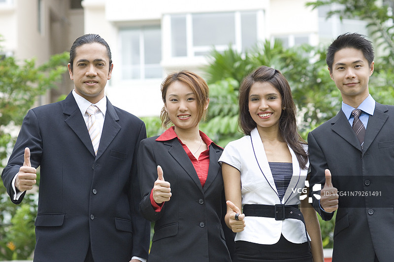 两位男商人和两位女商人竖起大拇指的肖像图片素材