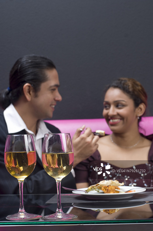 中年男人在餐厅喂年轻女人图片素材