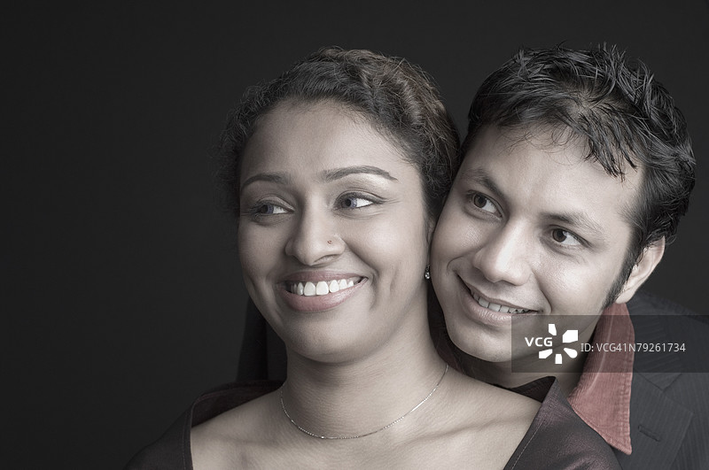 年轻情侣微笑着望向远方的特写镜头图片素材