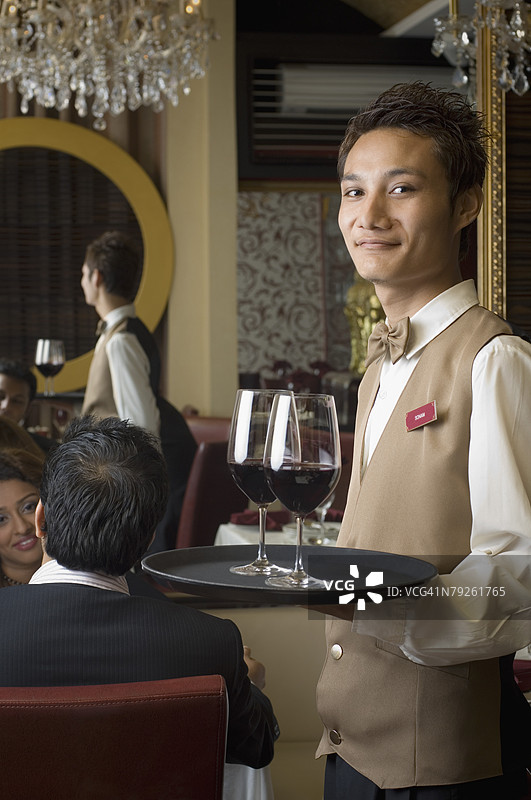 一位侍者手持托盘上的酒杯肖像图片素材