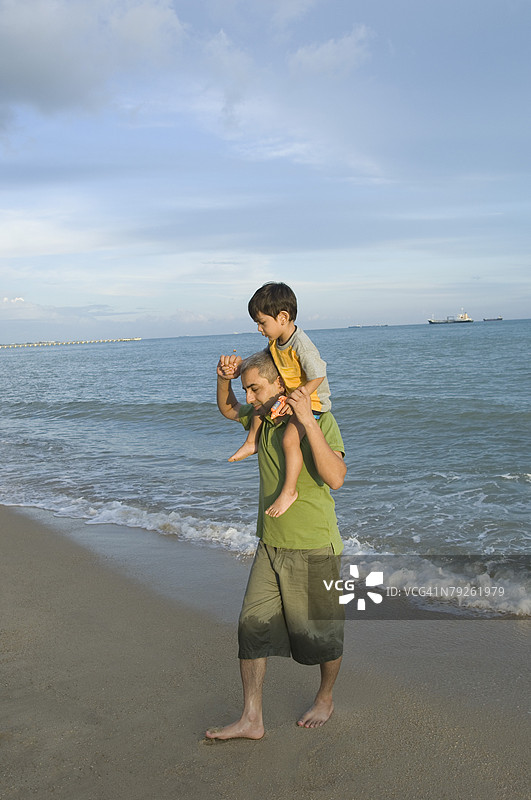 中年男子肩上扛着他的儿子图片素材