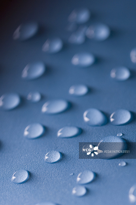 蓝色表面上的水滴特写图片素材