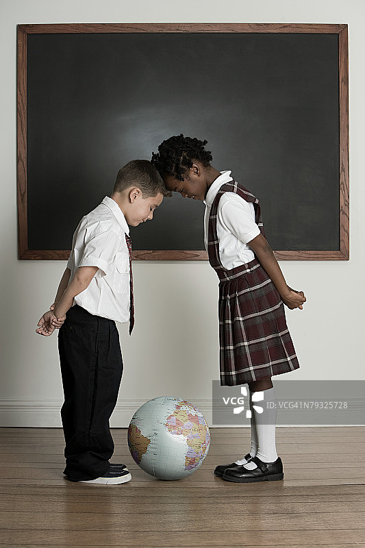 看着地球仪的男孩和女孩图片素材
