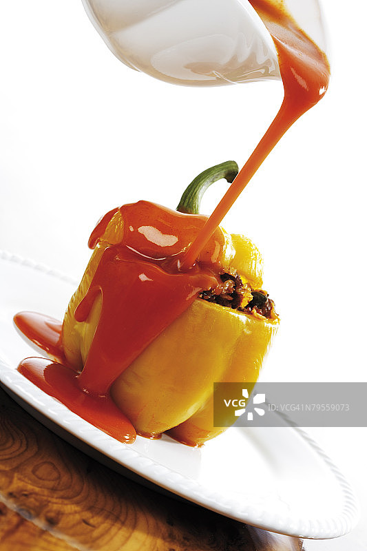 将番茄酱倒在酿有肉馅的甜椒上，倾斜视角图片素材