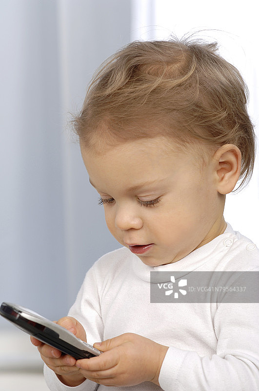 近距离拍摄使用手机的小孩图片素材