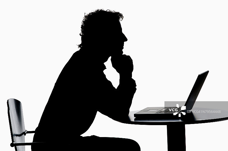 男人使用笔记本电脑的剪影图片素材