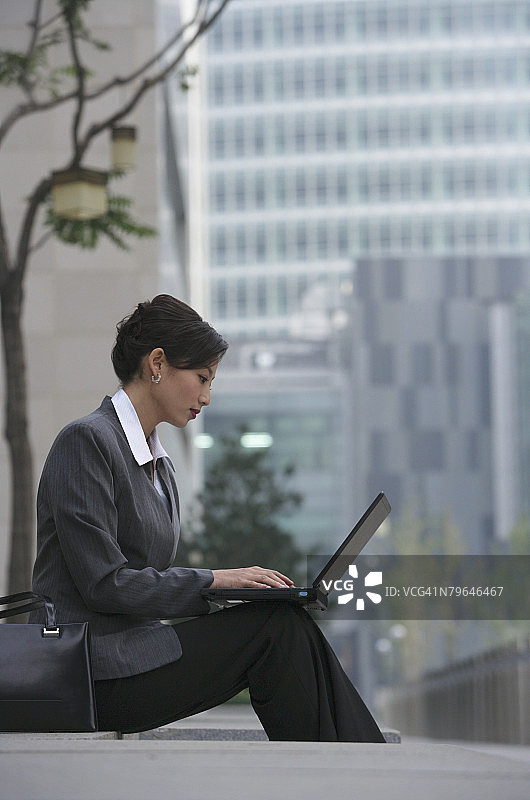 女商人坐下来使用笔记本电脑图片素材