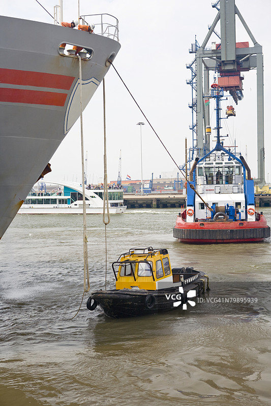 在鹿特丹港口，大型集装箱船在划船协会的帮助下靠岸。图片素材