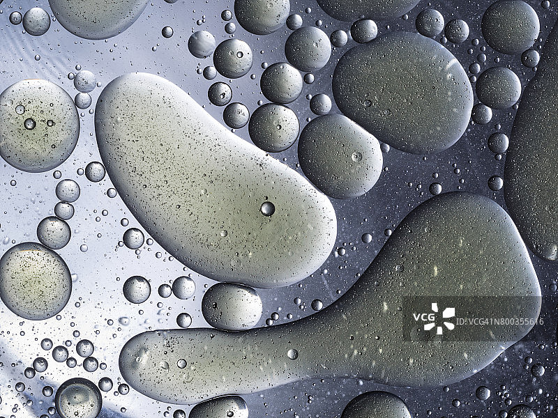 青铜色背景下油滴气泡圆形漂浮纹理特写图片素材