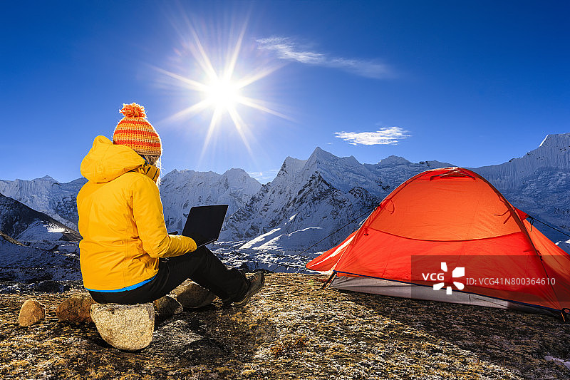 年轻女人在尼泊尔喜马拉雅山脉使用笔记本电脑图片素材