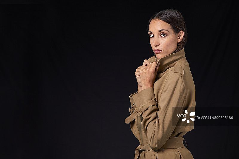 拿着风衣的年轻女子侧视图图片素材