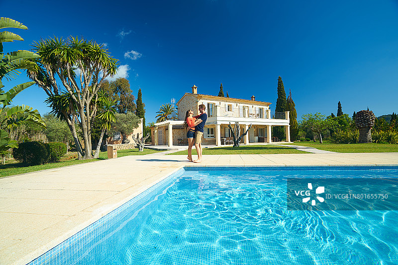 情侣在私人住宅泳池边拥抱图片素材