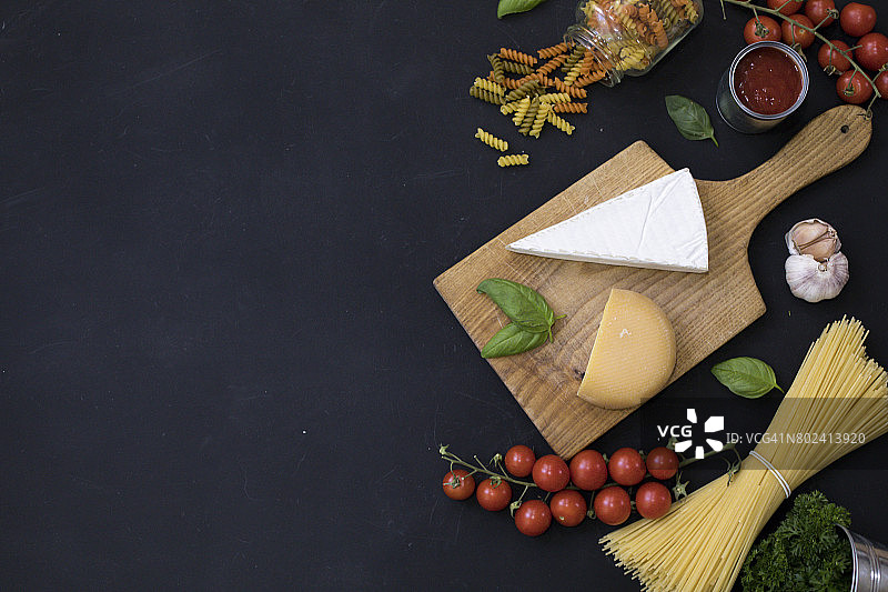 食物边框：意大利面食材，如樱桃番茄、意大利面、大蒜、罗勒、奶酪和香料图片素材