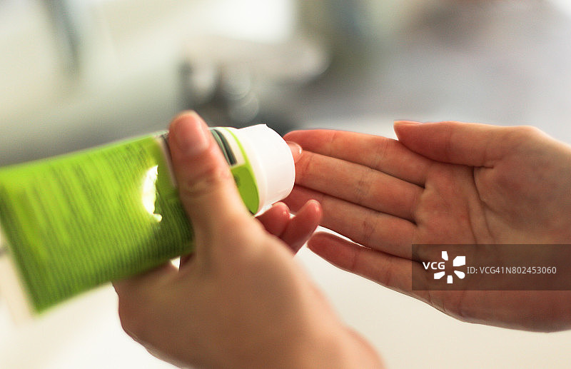 年轻女人从软管中挤出洗面奶图片素材