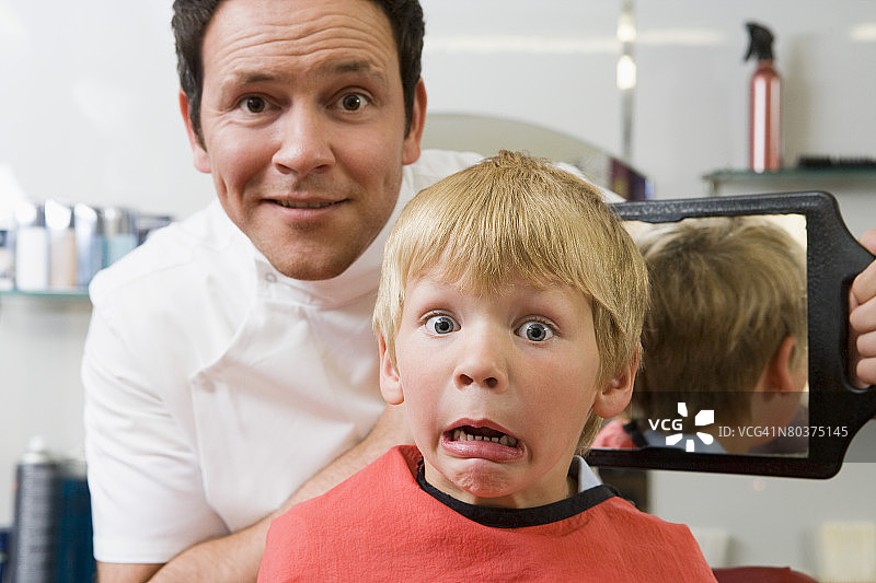 男孩观察理发效果图片素材