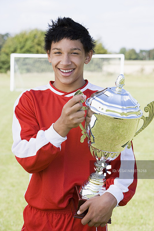 男孩足球运动员手持奖杯图片素材