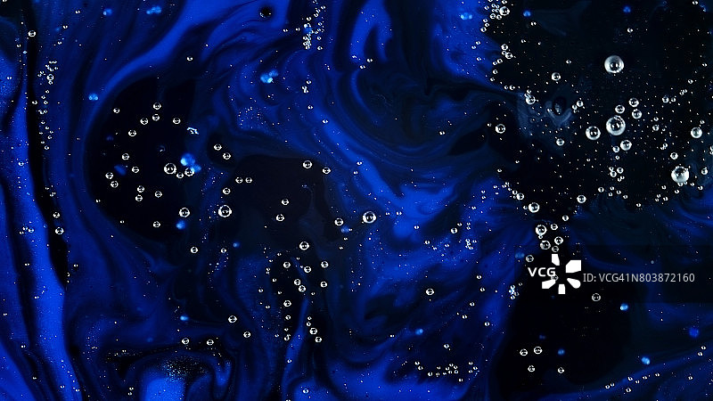 黑色和紫色背景上的蓝色闪光气泡图片素材