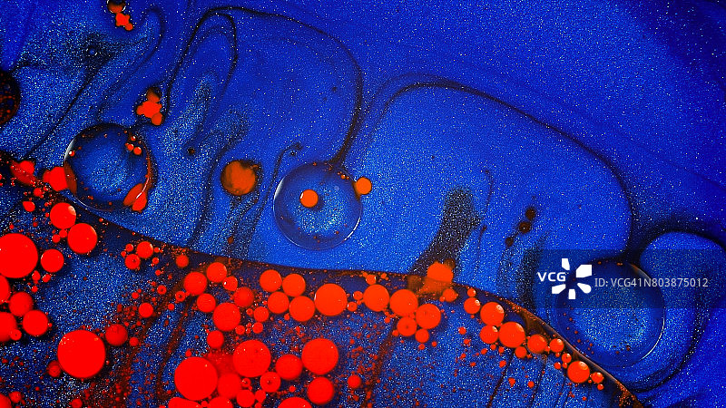 红色海浪涌过蓝色，鲜艳的油彩漩涡图片素材