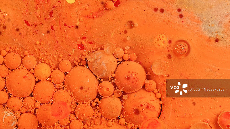 橙红色冰棒球体与鲜艳的油彩漩涡图片素材