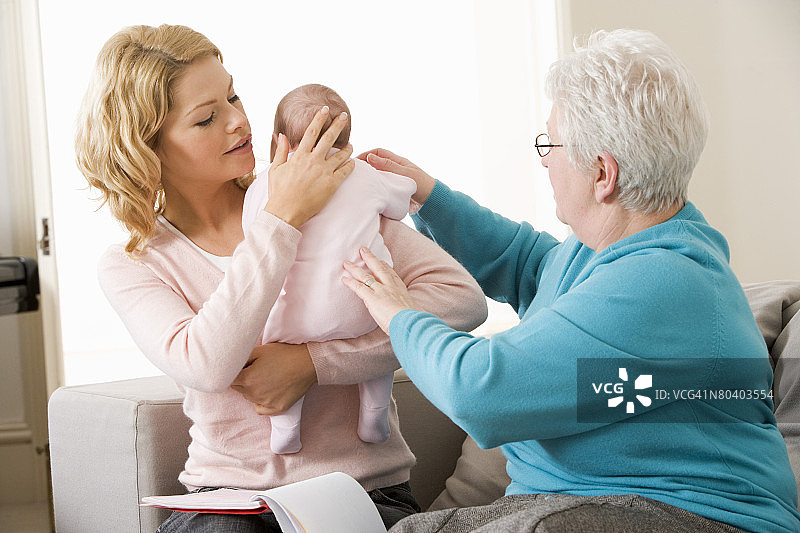 家庭医护人员帮助母亲和婴儿图片素材