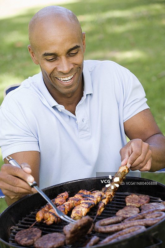 男子烧烤各种肉类图片素材