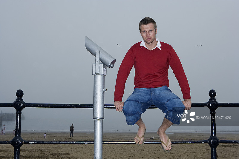 男人坐在栏杆上使用取景器图片素材