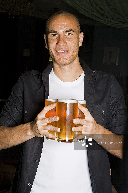 男人拿着三品脱啤酒图片素材