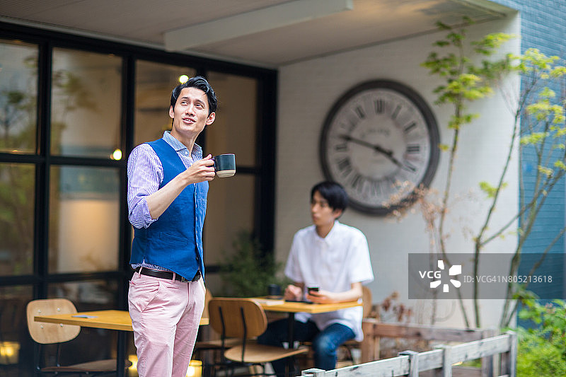 男子在城市咖啡馆的露台上享受户外咖啡图片素材