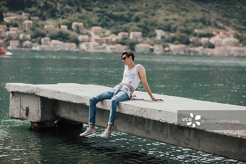 坐在水上码头上的英俊男人图片素材