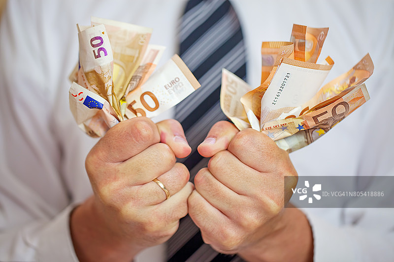 沉迷金钱，贪婪的商人榨取金钱。对金钱的爱。图片素材