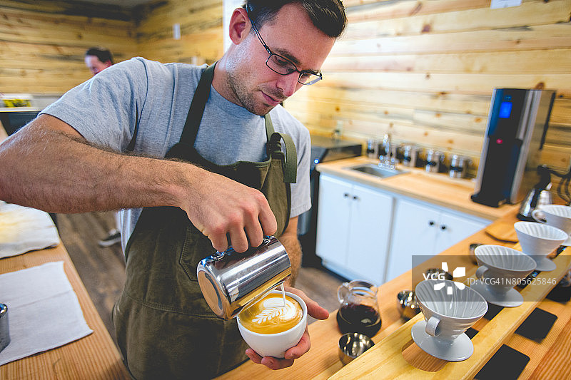 制作拿铁的年轻男咖啡师图片素材
