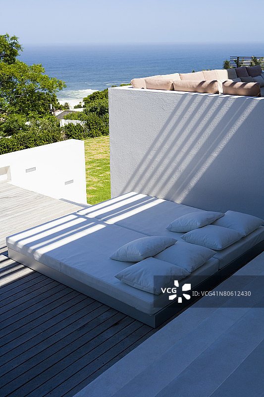 俯瞰海洋的露台上的日光浴床图片素材