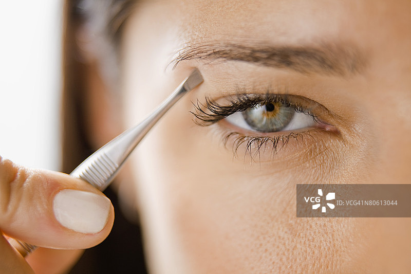 女人拔眉毛图片素材