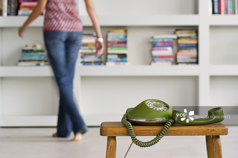 拿着听筒站在电话旁的女人图片素材