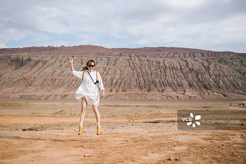 在吐鲁番火焰山拍摄的年轻女摄影师图片素材