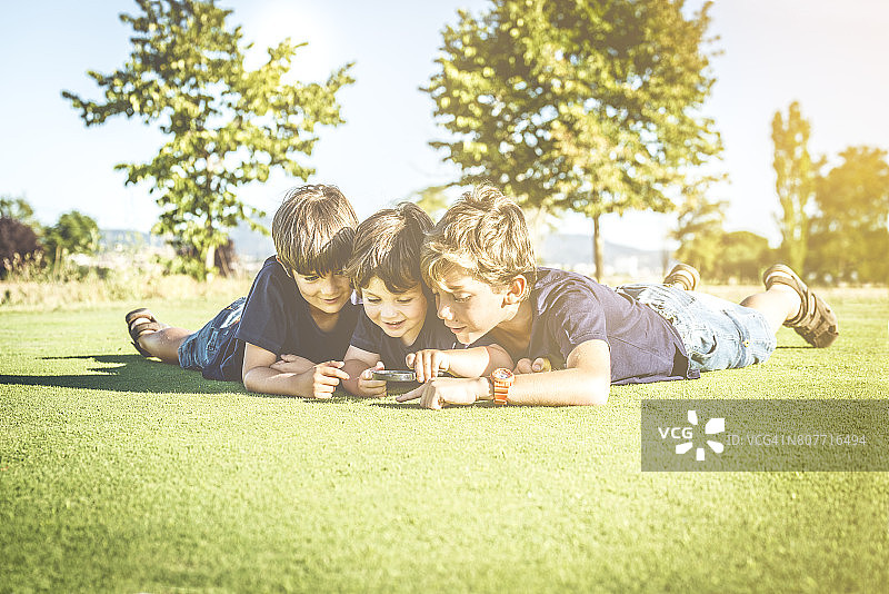 用放大镜观看的三个兄弟图片素材