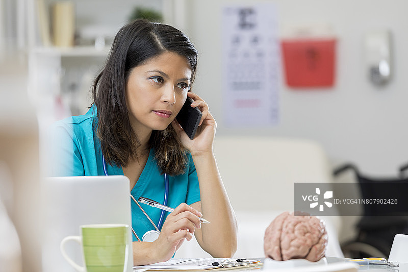 忧心忡忡的神经科医生使用智能手机图片素材