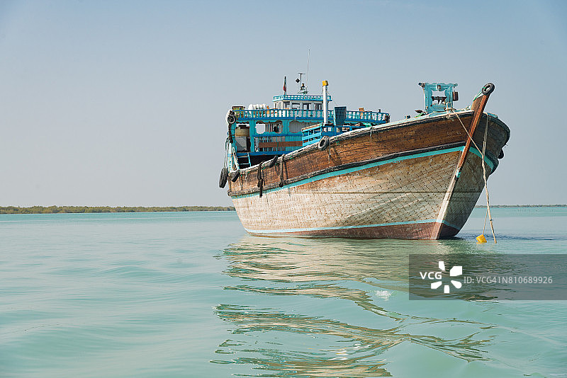 伊朗南部霍尔木兹甘省格什姆岛塔布尔附近哈拉红树林旁的蓝船图片素材