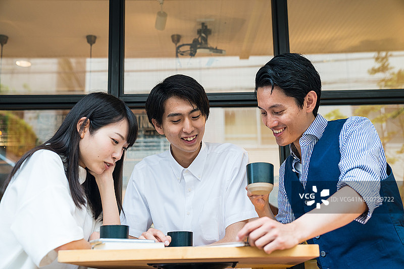 三位朋友一起看平板电脑图片素材